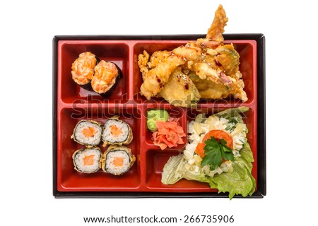 Japanese Meal in a Box (Bento) isolated on white background - classic salad, breaded shrimp and zucchini, sushi and rolls