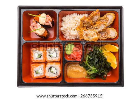 Japanese Meal in a Box (Bento) isolated on white background - shrimp, salad, baked chicken with rice, oranges, sushi and rolls