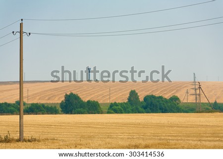 Agriculture field after harvesting and electric poles. Rural scene.