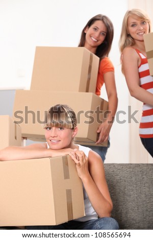 Three female flat-mates packing boxes