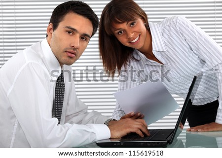 Two young business people working all hours to finish project