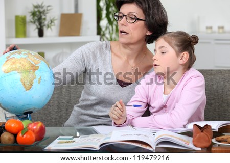 Mother teaching daughter geography