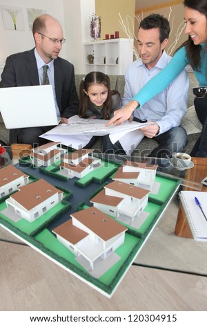 Family discussing a housing development with an architect