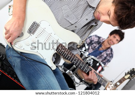 Landscape picture of guys with guitars and drums