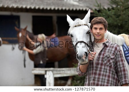 Man with horse in a stable