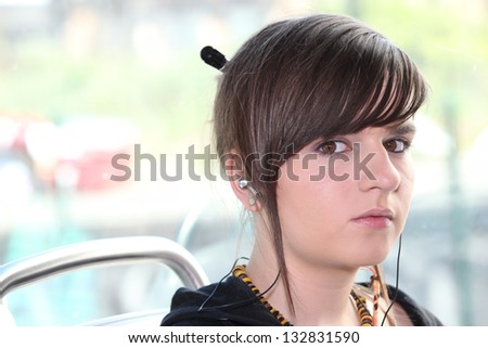 Closeup of girl with earphones sitting on a tram