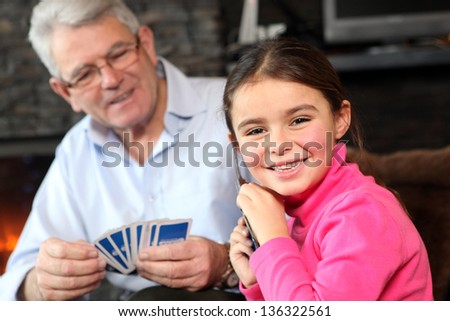 Young girl playing cards with grandpa