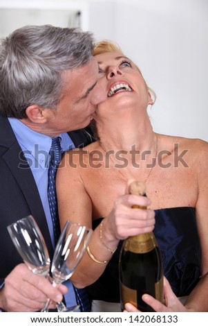 Couple popping a champagne cork