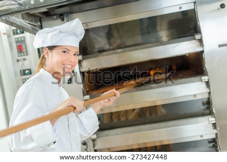 Female baker at bread oven