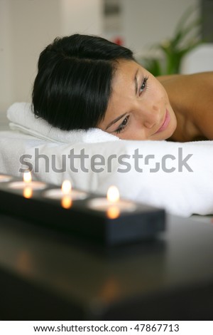 Portrait of beautiful woman on a massage bed with candle light