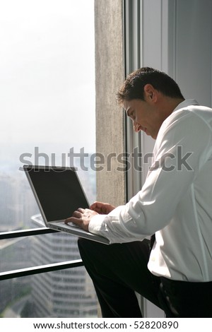 Man with a laptop computer in front of a window