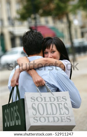 Happy woman embracing a man with sales bags