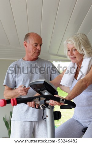 Portrait of an old man and of an old woman making of the exercise bike