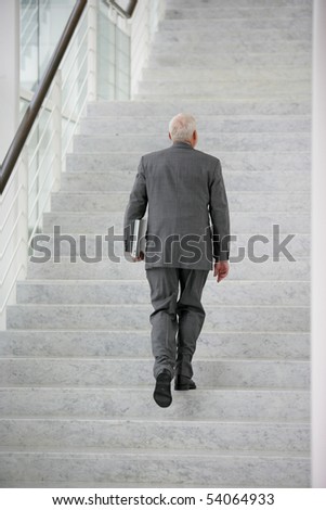 Senior man in suit climbing stairs