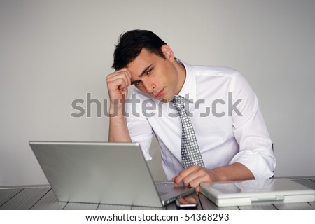 Portrait of a pensive man in suit in front of a laptop computer