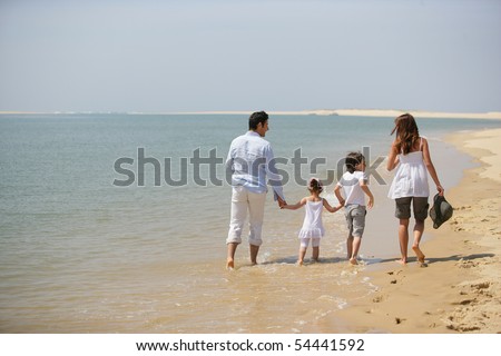 Family walking by the edge of the sea