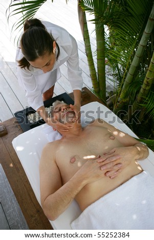 Portrait of a senior man being massaged by a young woman