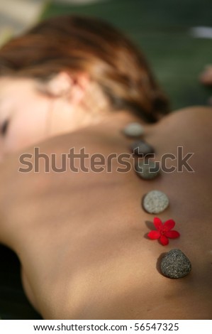 Laid woman having a hot stones massage