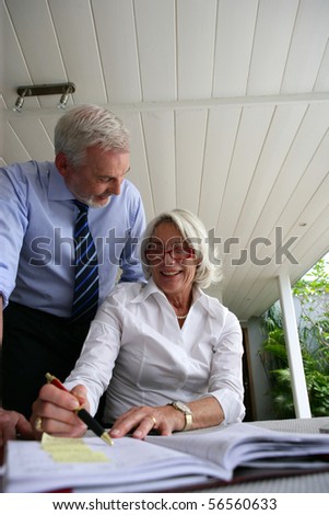 Senior couple in suit planning a meeting on a diary