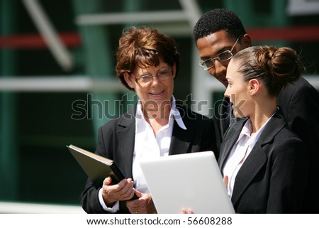 Portrait of business people in suit holding documents and a laptop computer