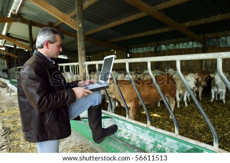 Farmer with a phone and a laptop computer
