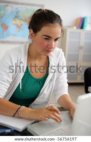 Portrait of a young girl in front of a laptop computer in a classroom