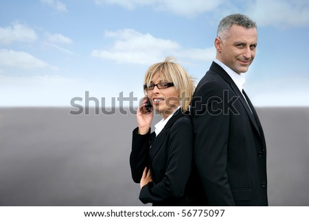 Man and woman in suit standing back to back