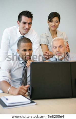 Portrait of business people in a meeting with a laptop computer