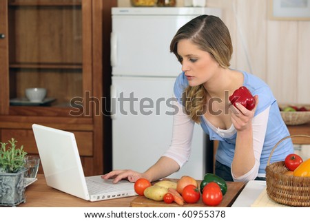 Young woman in front of a laptop computer in the kitchen