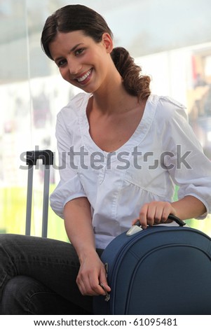 Portrait of a young woman with suitcase