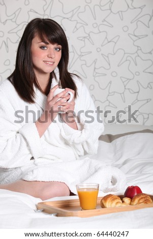 Woman in bathrobe with coffee in hand