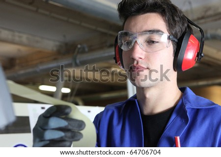 Worker with anti-noise headphones and goggles
