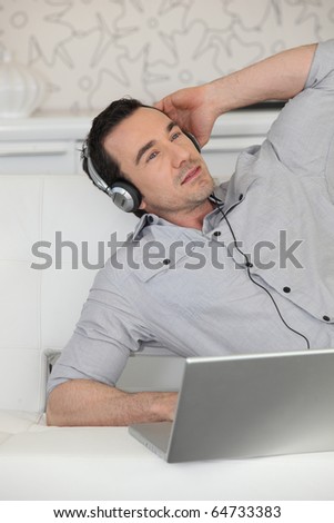 Man with headphones in front of a laptop