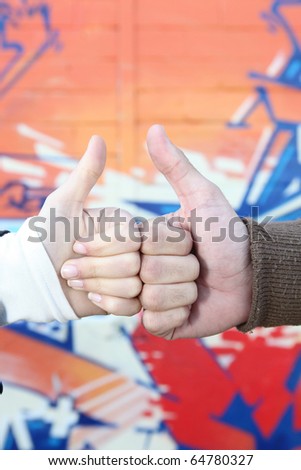 Hands in front of graffiti wall
