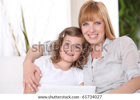 Woman and little girl in front of a laptop computer
