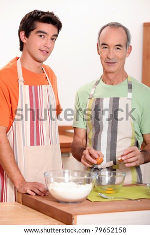 a young man and an old man making a cake