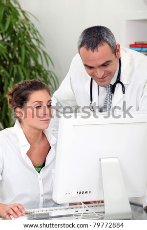 doctor and a medical secretary watching a computer
