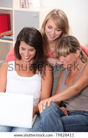 Three teenage girls watching laptop computer
