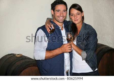 a couple drinking wine in a wine producer\'s cellar