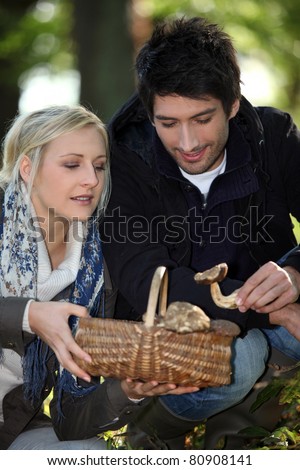 30 years old woman and man picking mushrooms