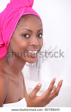 Woman in bathroom, drying hair