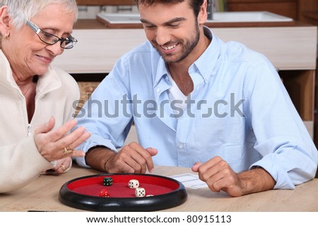 young man playing dice with older woman