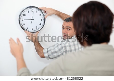 Couple straightening a crooked clock