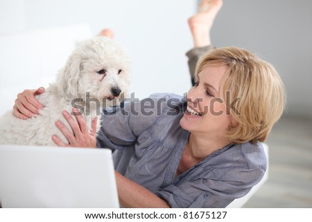 Woman smiling with dog and laptop