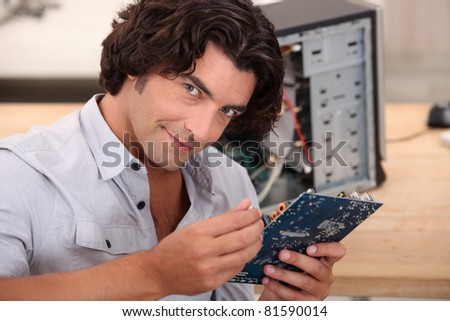 mid long hair man is repairing a computer