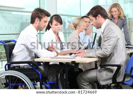 Man in wheelchair with colleagues in a meeting