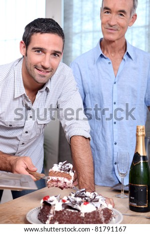 Two men cutting celebration cake