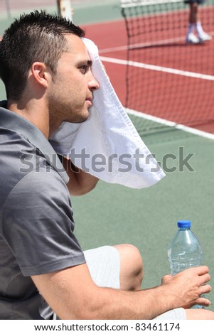 tennis player sweeping out the sweat from his forehead