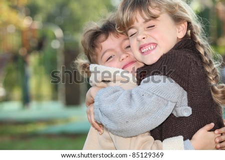 Young girls hugging outside
