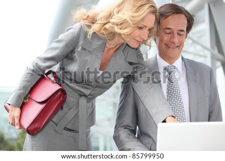 Business couple looking at laptop